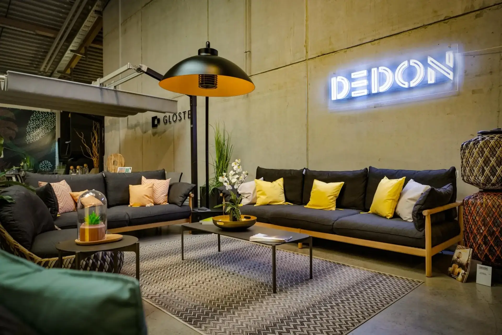 Sofa und Sitzgruppe von Dedon mit gelben Kissen und Heizstrahler in der Gartenmöbel-Ausstellung von Trendhouse in Fulda