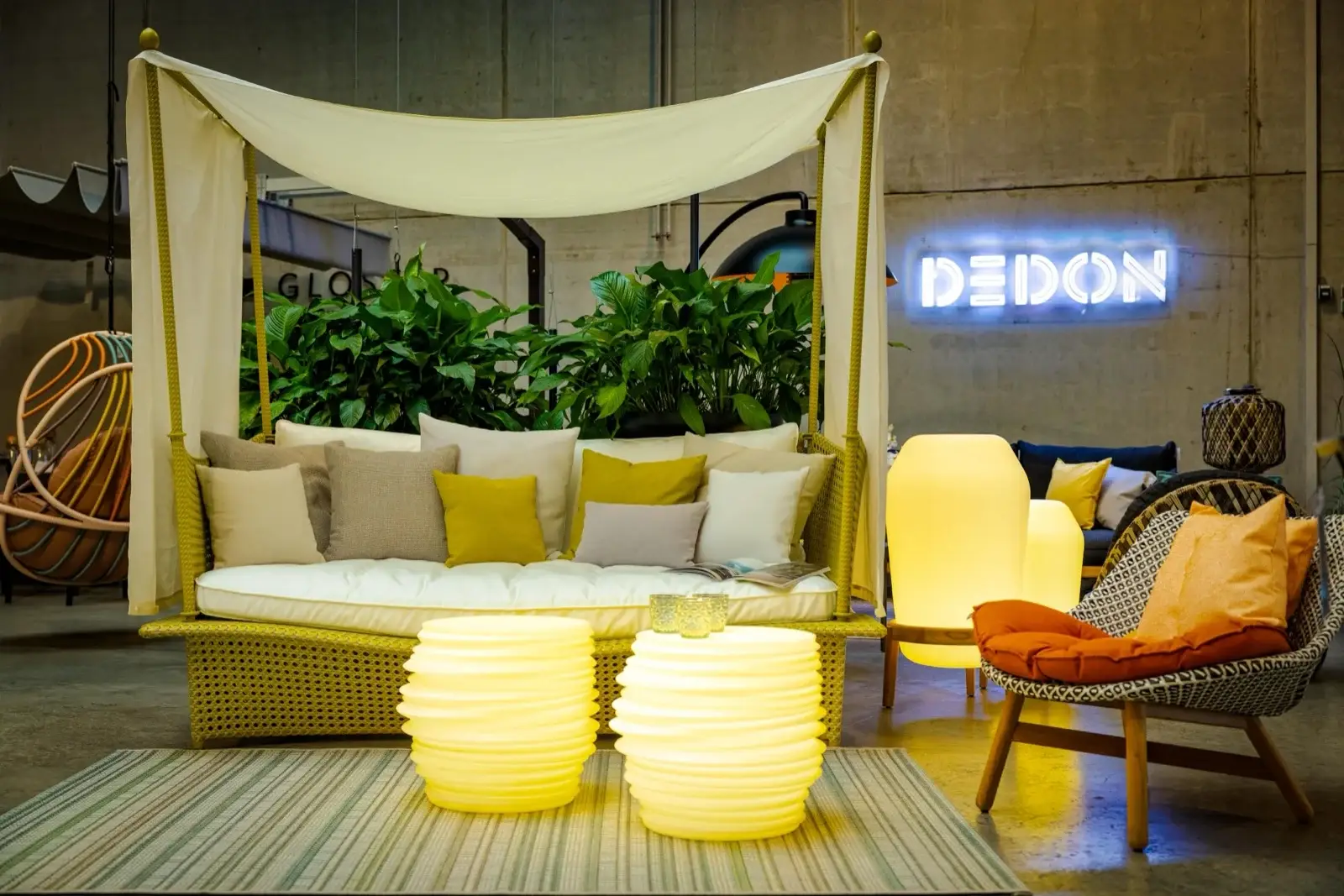 Leuchtende Outdoor-Leuchten, Kissen und ein Lounge-Bett mit Baldachin in der Ausstellung von Trendhouse in Fulda